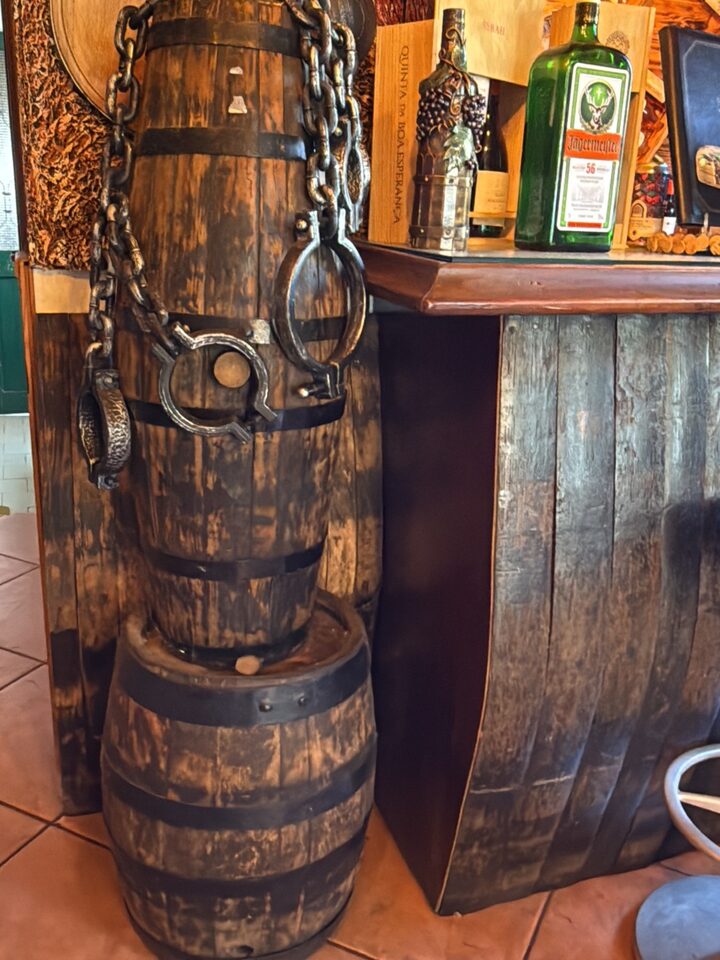 Old wine barrels and ironwork beside the bar inside the snack bar
